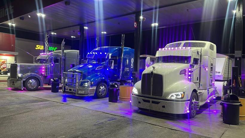 Three AREN trucks lined up fueling at night